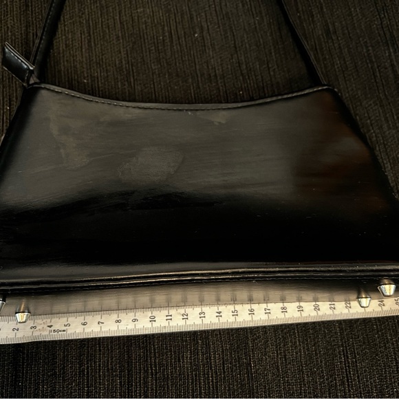 Black handbag. Silver coloured details on zip, feet on bottom and side detail - Picture 7 of 8
